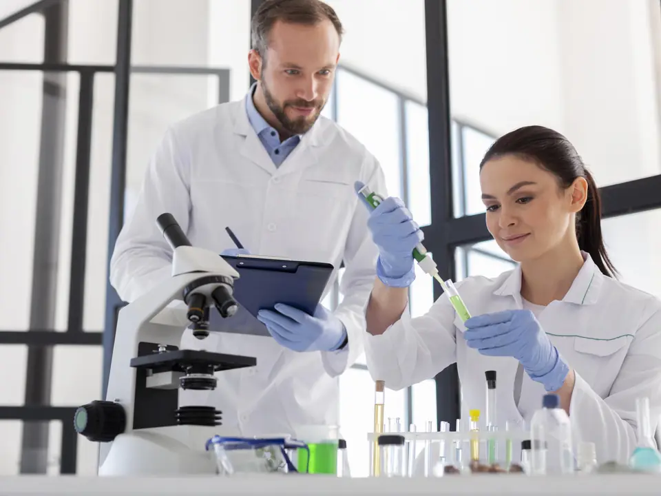 Equipe de laboratório veterinário analisando amostras com microscópio e tablet
